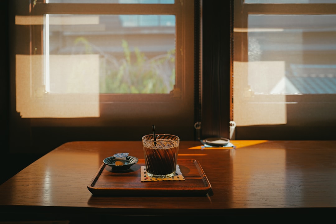 窓辺の木のテーブルに置かれたアイスコーヒー。引用イベントの行き先は、誰かの一杯を決めるごく日常的な選択でしかない