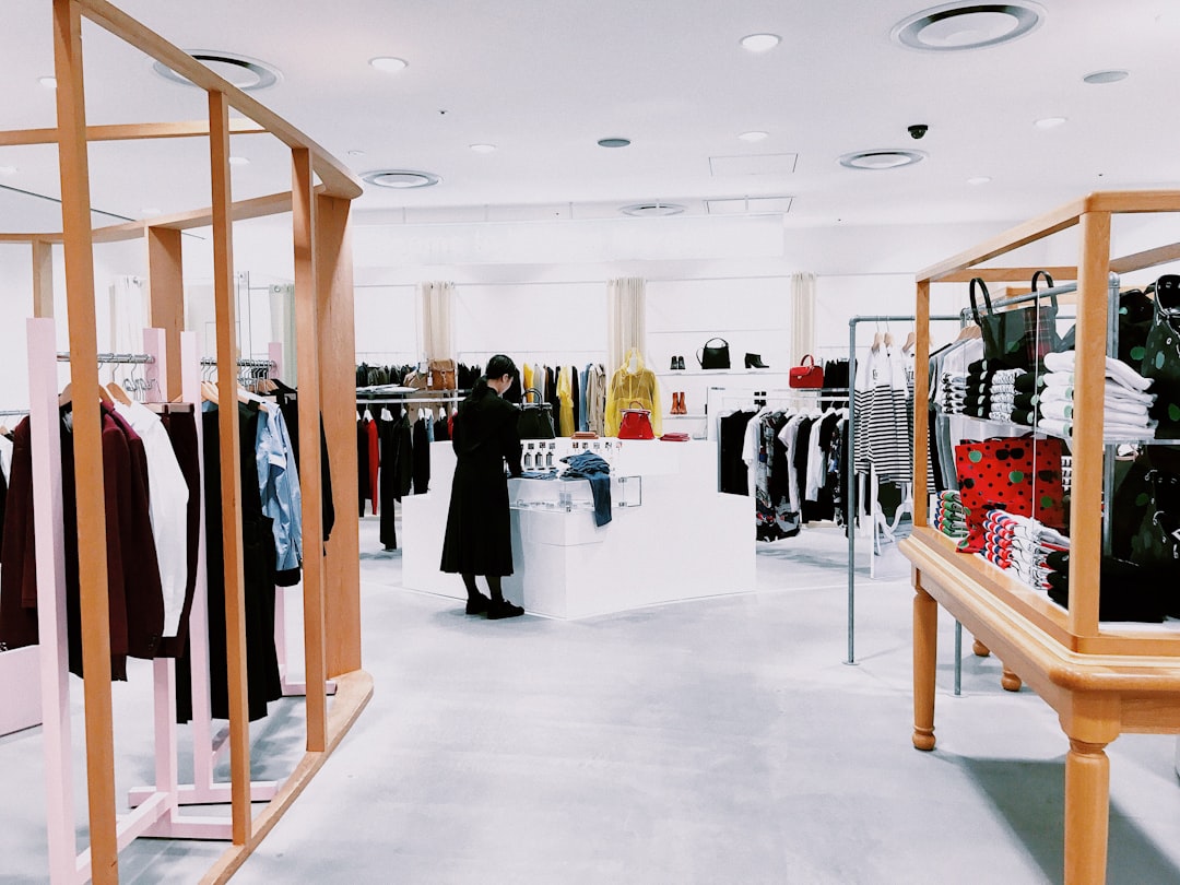 A woman inside a clothing shop — the kind of retail floor where the same six or seven customer questions repeat all day, and the answer to which schema type wraps them decides how an assistant cites the store