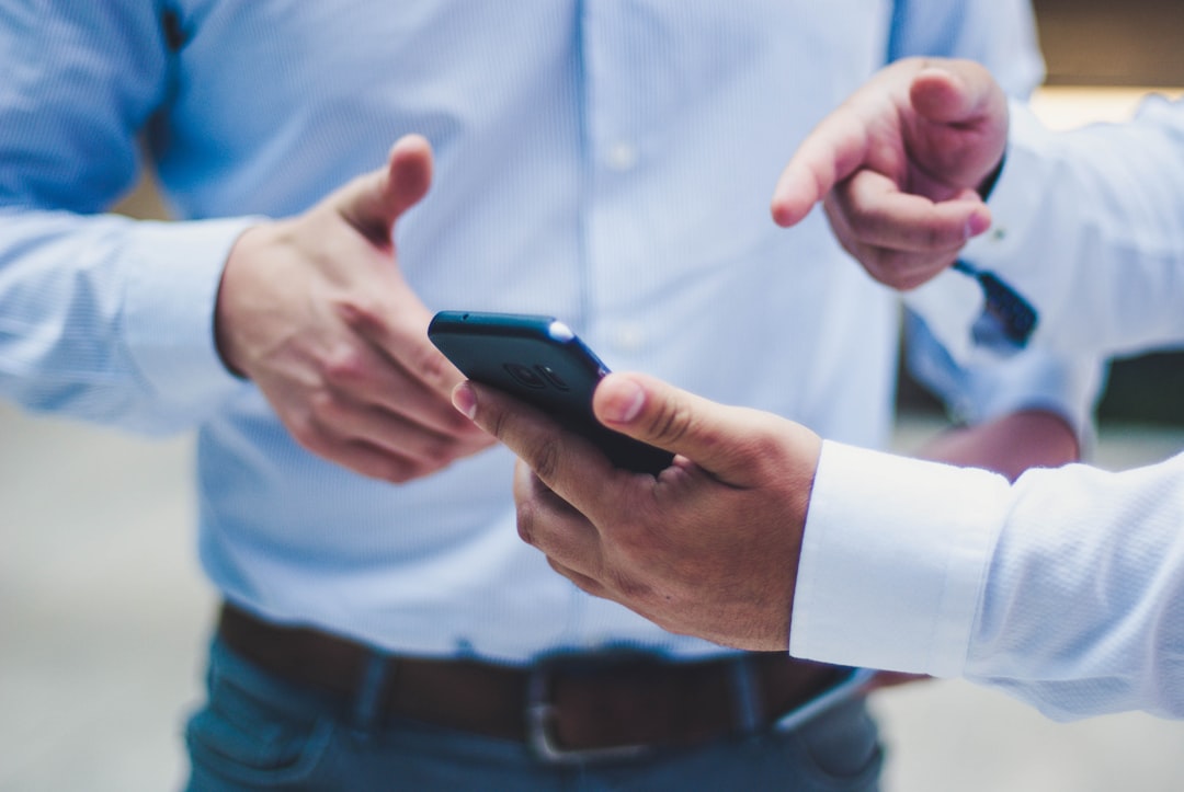A customer on a smartphone composing the single-question query ('do you accept PayPay?') that a QAPage-per-Q&A layout is designed to intercept as a direct citation