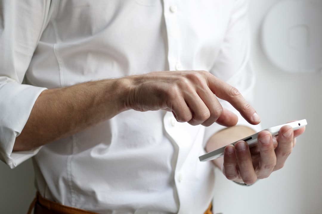 スマートフォンを手に取る人。利用者が「何を出す店か・いくらか」をその場で確認する行動
